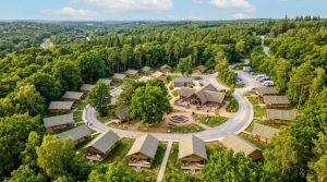 Aerial view of glamping site with safari tents surrounded by woodland